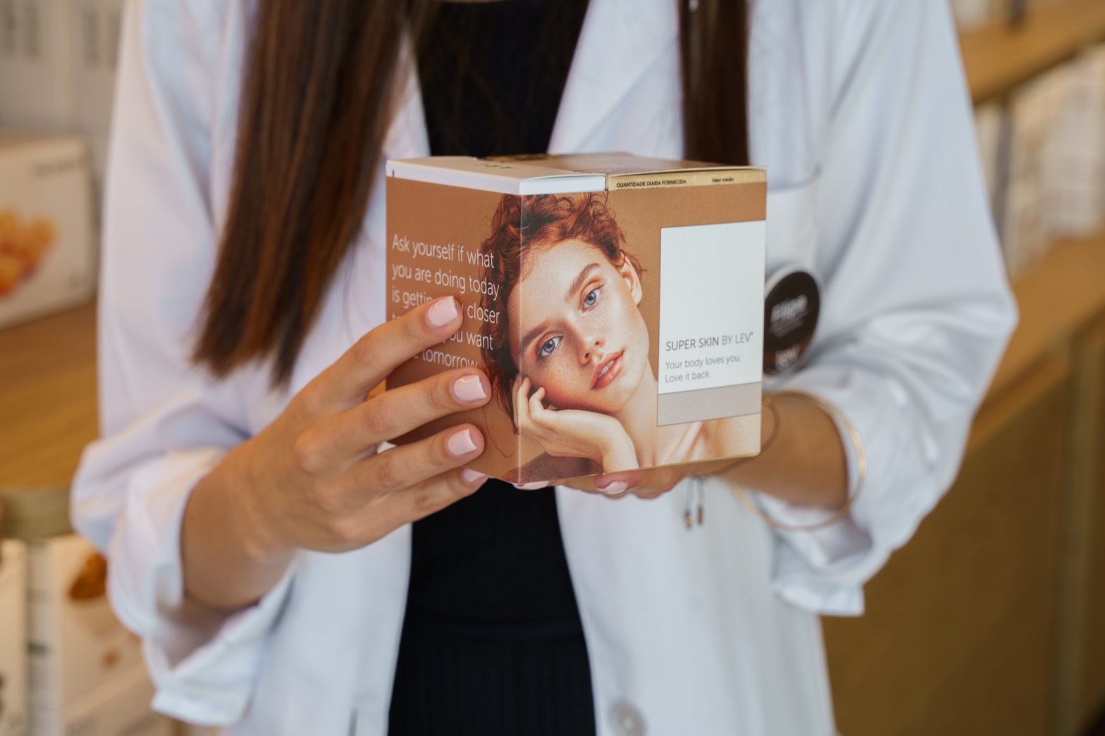 nutricionista da lev com o suplemento para a pele the skin elixir na mão