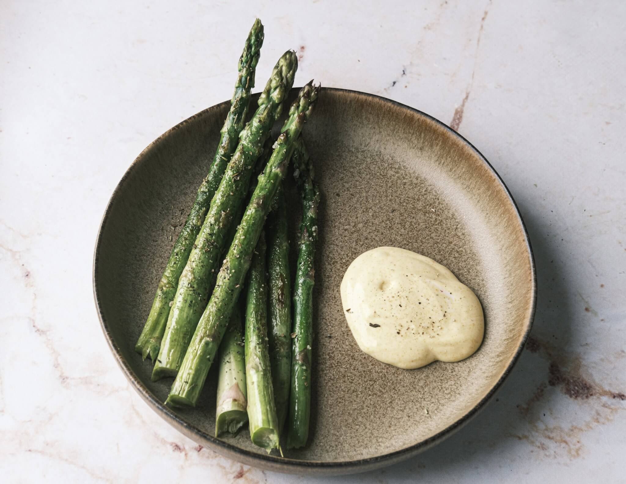 espargos grelhados com maionese saudável num prato