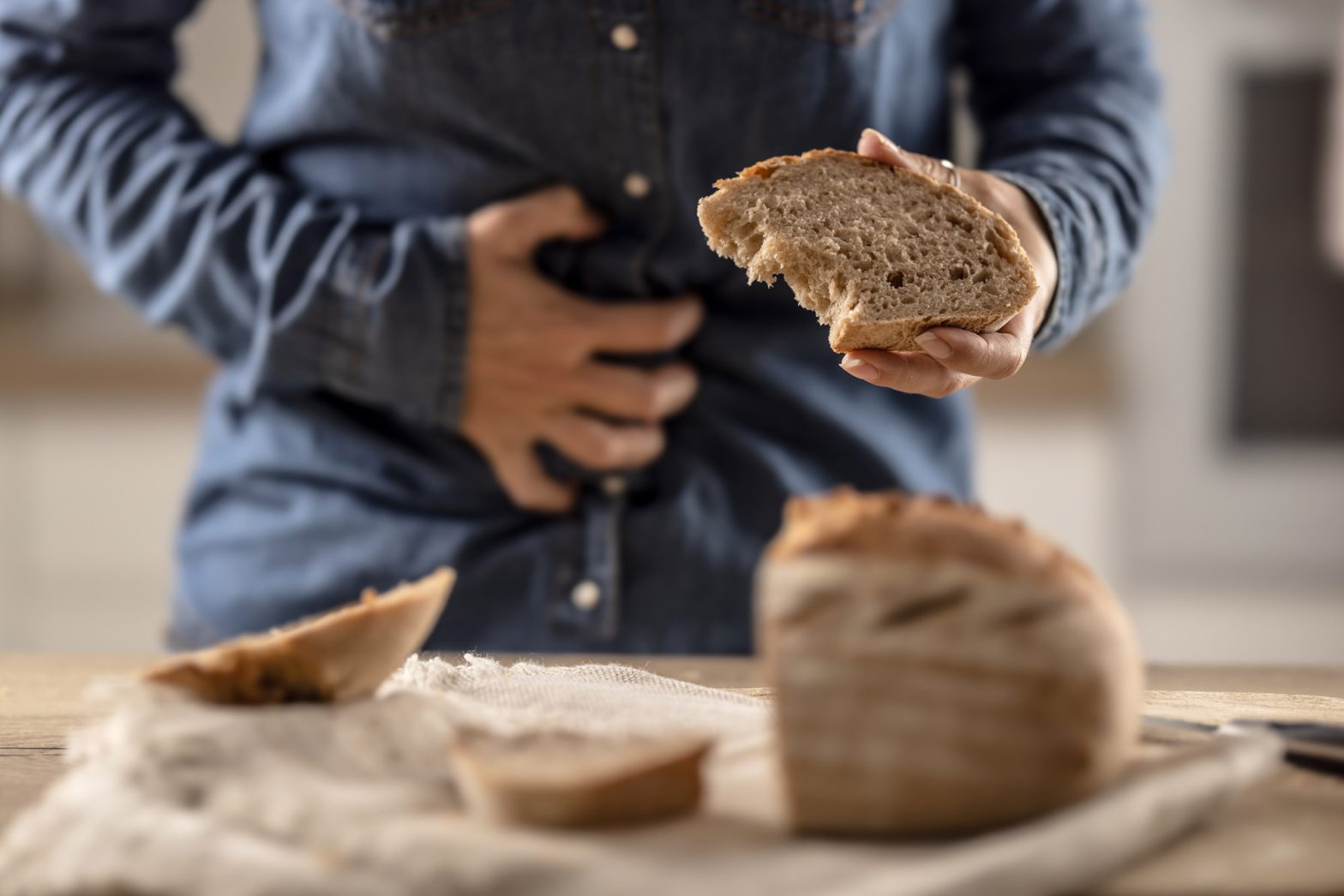 homem tem dores de barriga com uma fatia de pão na mão
